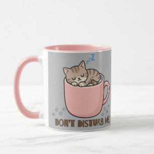 Joli petit chat endormi dans une tasse à thé
