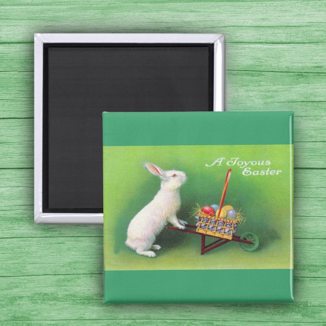 Joyous Ostersonne und Wheelbarrow Magnet (White Easter Rabbit pushing wheelbarrow with coloured Easter Eggs on green Magnet.)