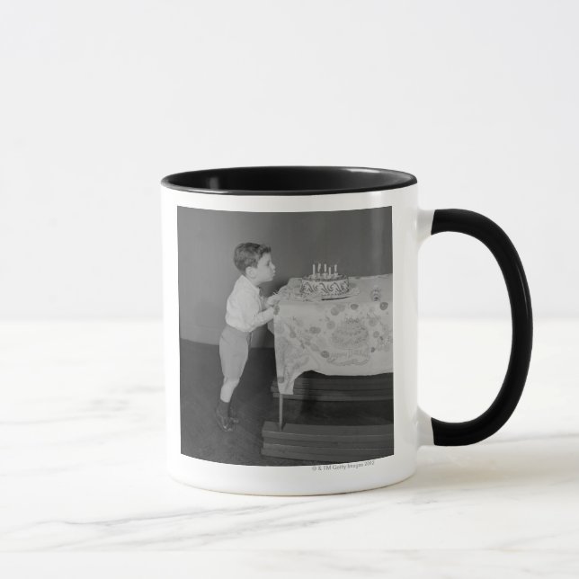 Junge bläst Kerzen aus Tasse (Rechts)