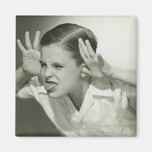 Junge, der Gesicht macht Magnet