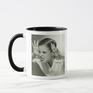 Junge, der Gesicht macht Tasse