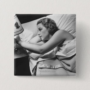 Junge Frau, die auf dem Bett an abstellt Lampe Button