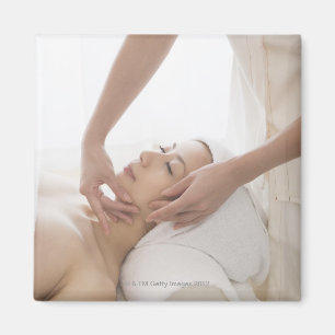 Junge Frau, die Gesichtsmassage hat Magnet