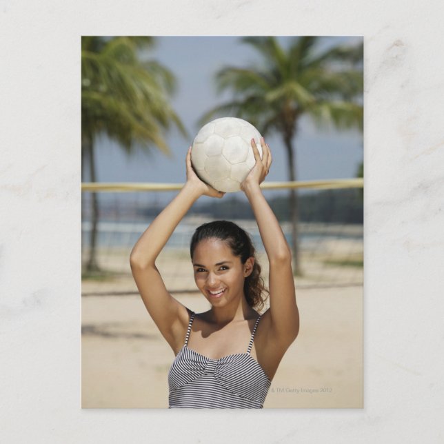Junge Frau, die Volleyball hält und lächelt bei Postkarte (Vorderseite)