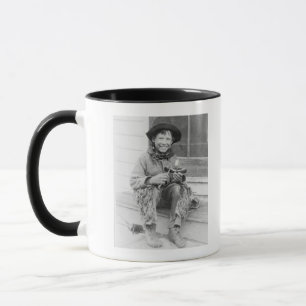Junge gekleidet als Cowboy mit Spielwaren Tasse