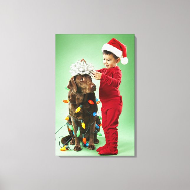 Junge Junge packt Weihnachtsleuchten um einen Hund Leinwanddruck (Vorderseite)