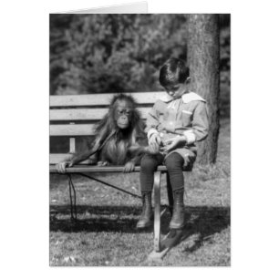 Junge sitzt mit Orang-Utan im Nationalen Zoo