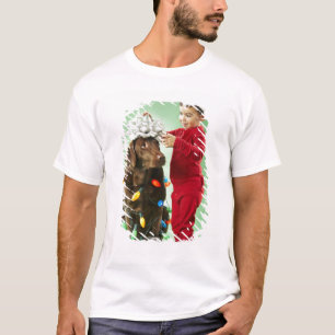 Junger Junge, der Weihnachtslichter um einen Hund T-Shirt