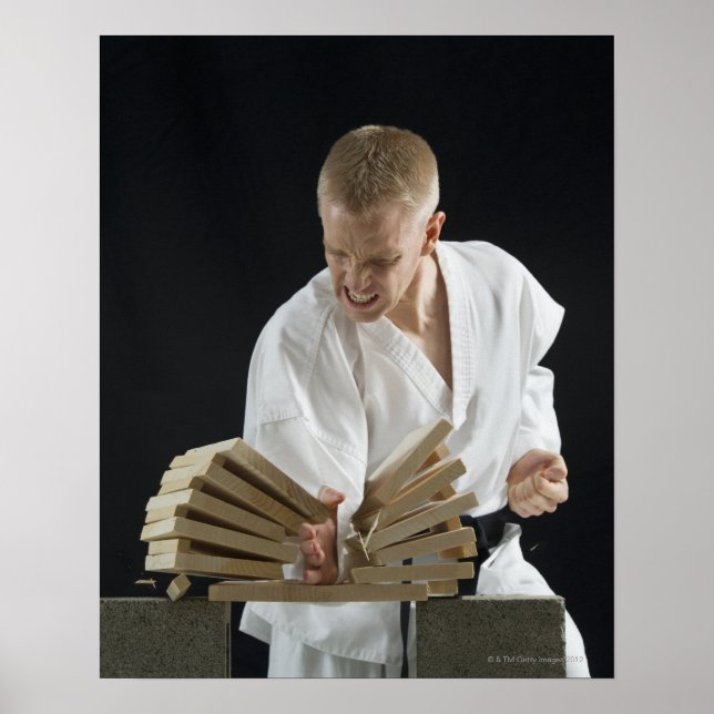 Junger Mann bricht Bretter mit Karate-Chop auf Poster (Vorne)