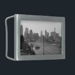 Kansas City Urban Skyline, Schwarz-Weiß-Foto Rechteckige Gürtelschnalle<br><div class="desc">In Kansas City, Missouri, erstreckt sich die sechsspurige Hauptstraße von der unteren rechten Ecke des Schwarz-Weiß-Fotos in Richtung des miessigen Wolkenkratzer-Horizonts in der Ferne. Ein dunkler Limousine, unterhalb und links von der Mitte, fährt senkrecht zu den Fahrspuren und schafft einen Moment der Intrige in der Stadtumgebung. Um das Foto Downtown...</div>