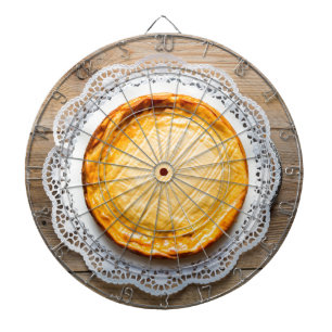 Käsekuchen auf rustikalen Holzkuchen oben. Dartscheibe