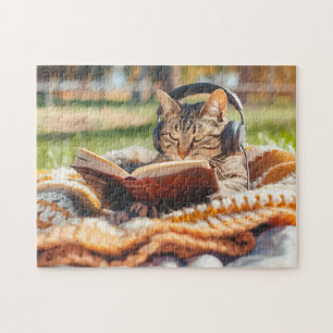 Katze liest Buch auf gestrickter Decke