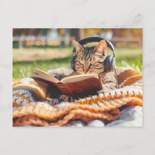 Katze liest Buch auf gestrickter Decke Feiertagspostkarte