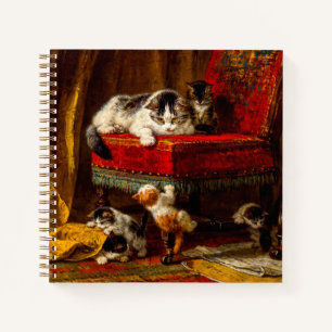 Katze und Kätzchen spielen mit Stuhl Notizbuch