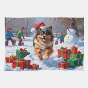 Keeshond-Hund läuft im Schnee mit Weihnachtsmütze Geschirrtuch