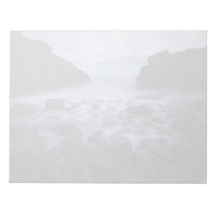 Kiesel und Felsen entlang der Küste des Ozeans Notizblock