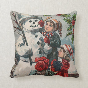 Kinder machen Schneemann mit Stechpalme Kissen
