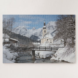 Kirche im Schnee mit den Alpen im Winter