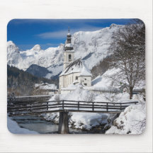 Kirche im Schnee mit den Alpen