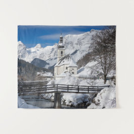 Kirche im Schnee mit den Alpen Wandteppich