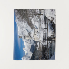 Kirche im Schnee mit den Alpen Wandteppich