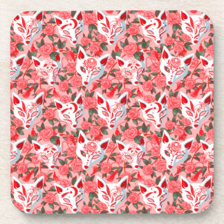 Kitsune Masken und blühende Kamelie auf rosa Getränkeuntersetzer