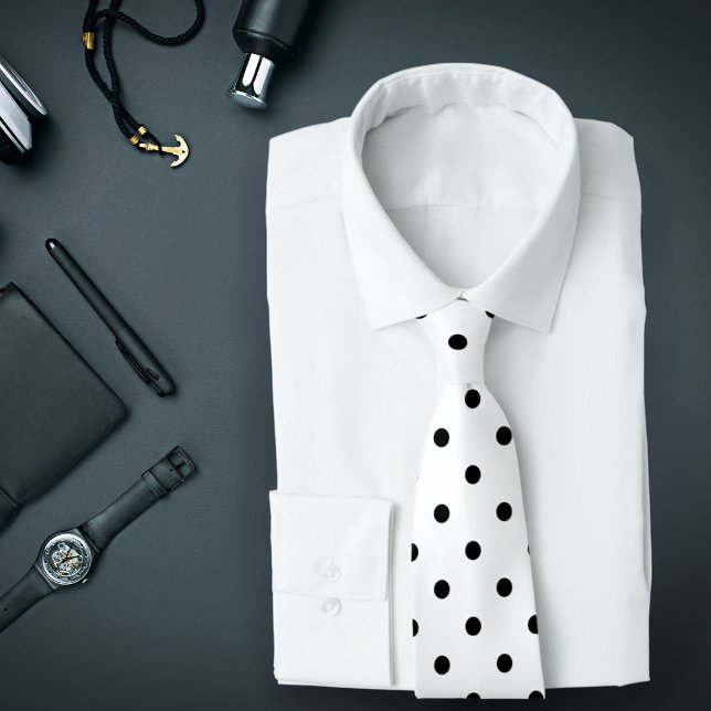 Klassisches Schwarz-Polka-Punktmuster auf weißer K Krawatte (A white tie with black polka dots is featured on an assemblage of men's accessories.)