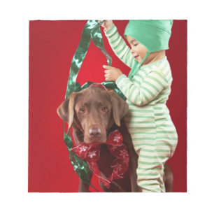 Kleiner Junge, der einen Hund schmückt Notizblock