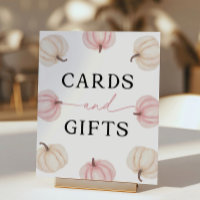 Kleiner Kürbis, der eine Karte und Geschenke dreht