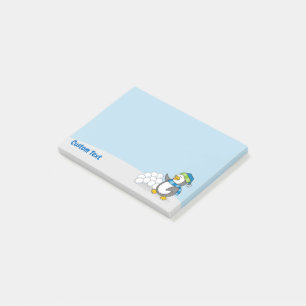 Kleiner Pinguin mit Schneeballschuhen, der nach de Post-it Klebezettel