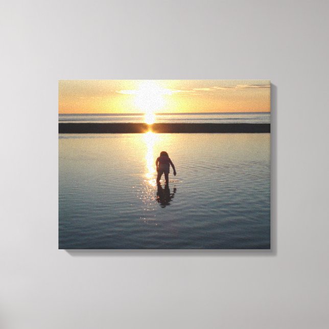 Kleines Mädchen spielt bei Sonnenuntergang im Wass Leinwanddruck (Vorderseite)