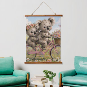 Koala-Freunde beim Radfahren durch blühende Wildbl Wandteppich Mit Holzrahmen