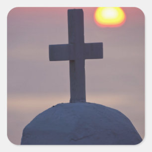 Kreuz auf der Spitze einer Kirche bei Sonnenunterg Quadratischer Aufkleber