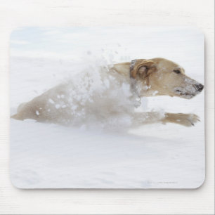 Labrador retriever, das durch tiefen Schnee läuft Mousepad