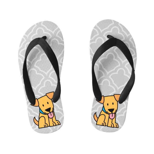 Labrador-Retrieverwelpenhund sitzen goldenen Kinderbadesandalen (Fußbett)