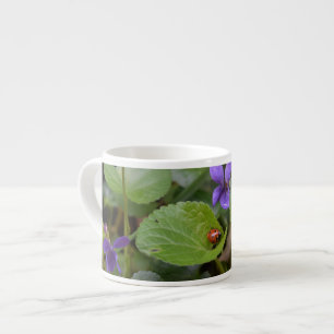 Ladybug über süße Violettsorten-Blume Espressotasse