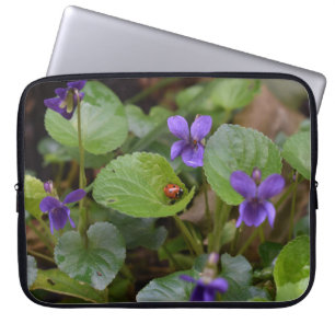 Ladybug über süße Violettsorten-Blume Laptopschutzhülle
