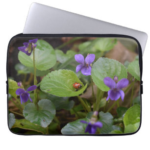 Ladybug über süße Violettsorten-Blume Laptopschutzhülle