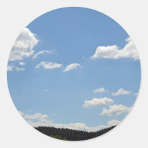 Landschaft mit grünen Hügeln, Bäumen und Wolken