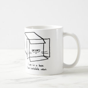 Le chat fâché se cache dans une boîte - tasse de