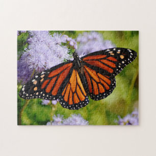 Le papillon Monarque au puzzle des fleurs violette