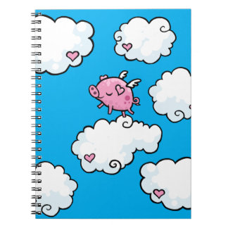 Le porc de vol danse sur le carnet en spirale de