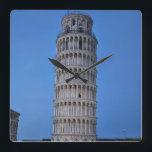 Leaning Tower at Dusk Quadratische Wanduhr<br><div class="desc">This captivating photograph showcases the iconic Leaning Tower of Pisa standing elegantly against a deep blue twilight sky in Pisa. The historic marble tower, famous for its unmistakable tilt, is beautifully illuminated, highlighting its intricate Romanesque arches and layered columns. The soft evening light creates a striking contrast between the glowing...</div>