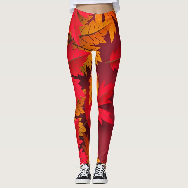 Leggings Automne ( A model showcases vibrant leggings adorned with autumn leaves in shades of red and orange. )