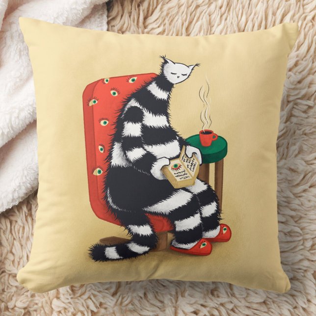 Lesen des Katalogbuches Kissen (close up of a pillow opn floor with image of weird cat reading book
)