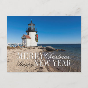 Leuchtturm am Strand mit einem Weihnachtskranz Feiertagspostkarte