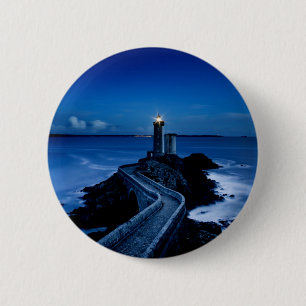 Leuchtturm an der Wand im Ozean in der Nacht Button