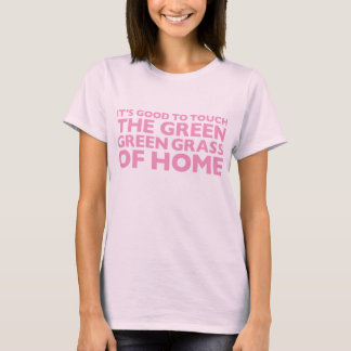 L'herbe verte verte du T-shirt rose à la maison
