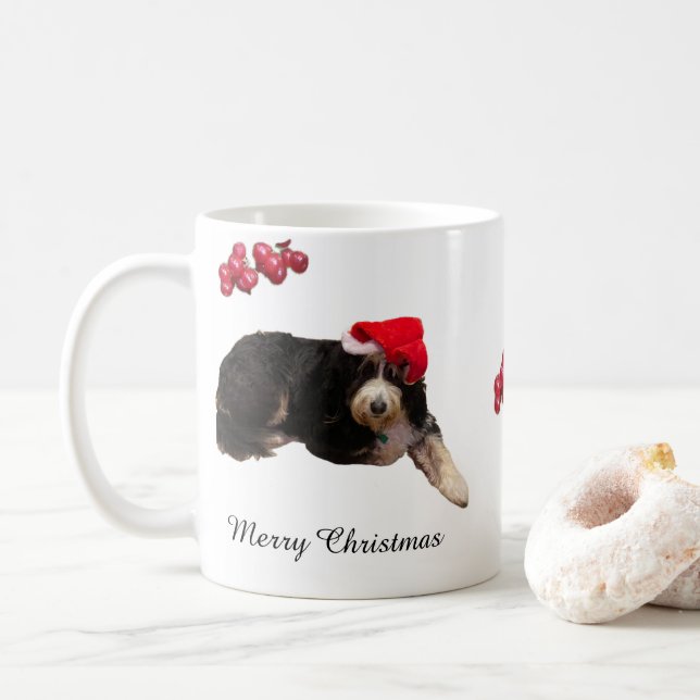 Lieblicher Hund mit einer Weihnachtsmannmütze an e Kaffeetasse (Mit Donut)
