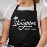 Like Daughter Sous Chef Typography Design Schürze<br><div class="desc">This design features a playful white cooking quote on a bold black background, highlighted with elegant script lettering and a small chef hat icon. The phrase “Like Daughter Sous Chef” gives it a fun family-and-kitchen theme that stands out with clean, high-contrast styling. Its mix of flowing typography and simple layout...</div>